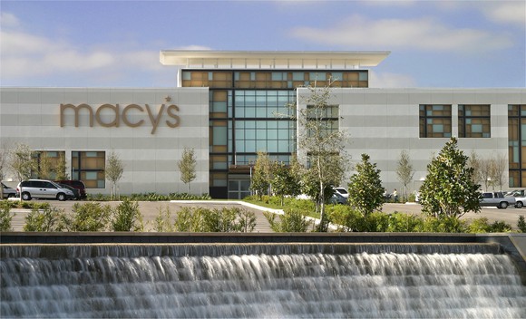 The exterior of a Macy's store, with a manufactured waterfall in the foreground.