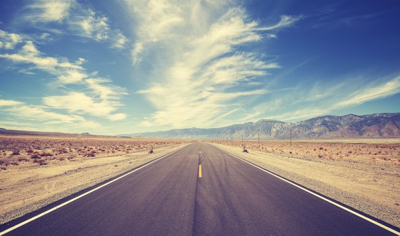 A road stretches into the distance in a desert.