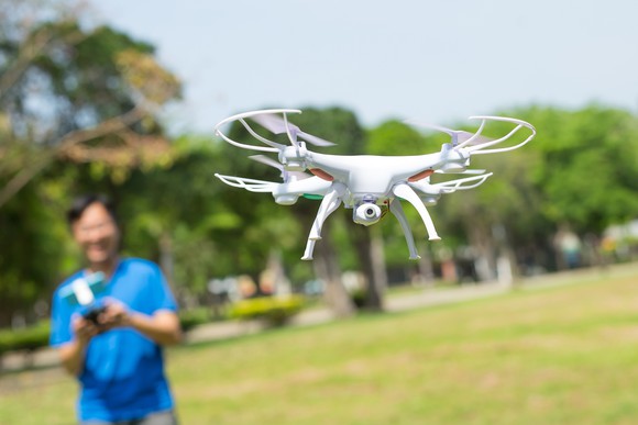 Man playing with quadcopter drone in a park
