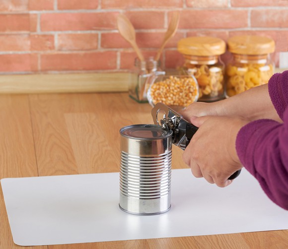 Someone uses a manual can opener.