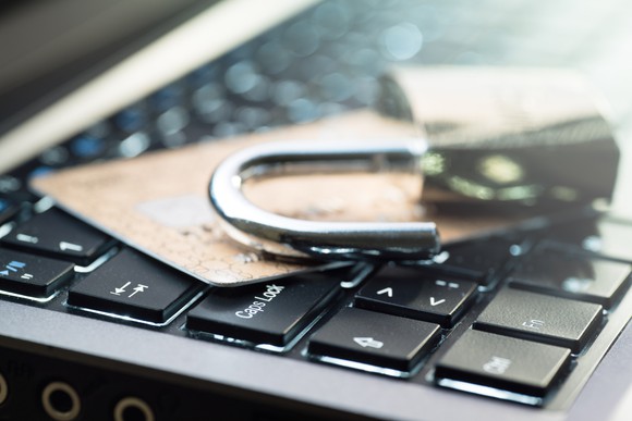 An open padlock on credit cards on computer keyboard