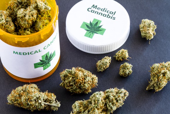 A medical cannabis prescription bottle filled with cannabis buds.