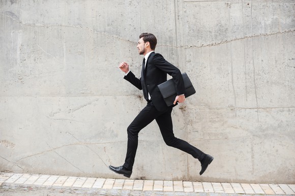A businessman, who appears to be in a hurry, carrying a briefcase.