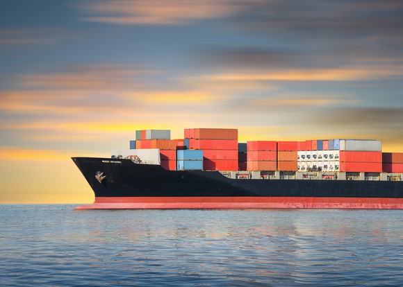 Cargo ship sailing in ocean at dawn or dusk.