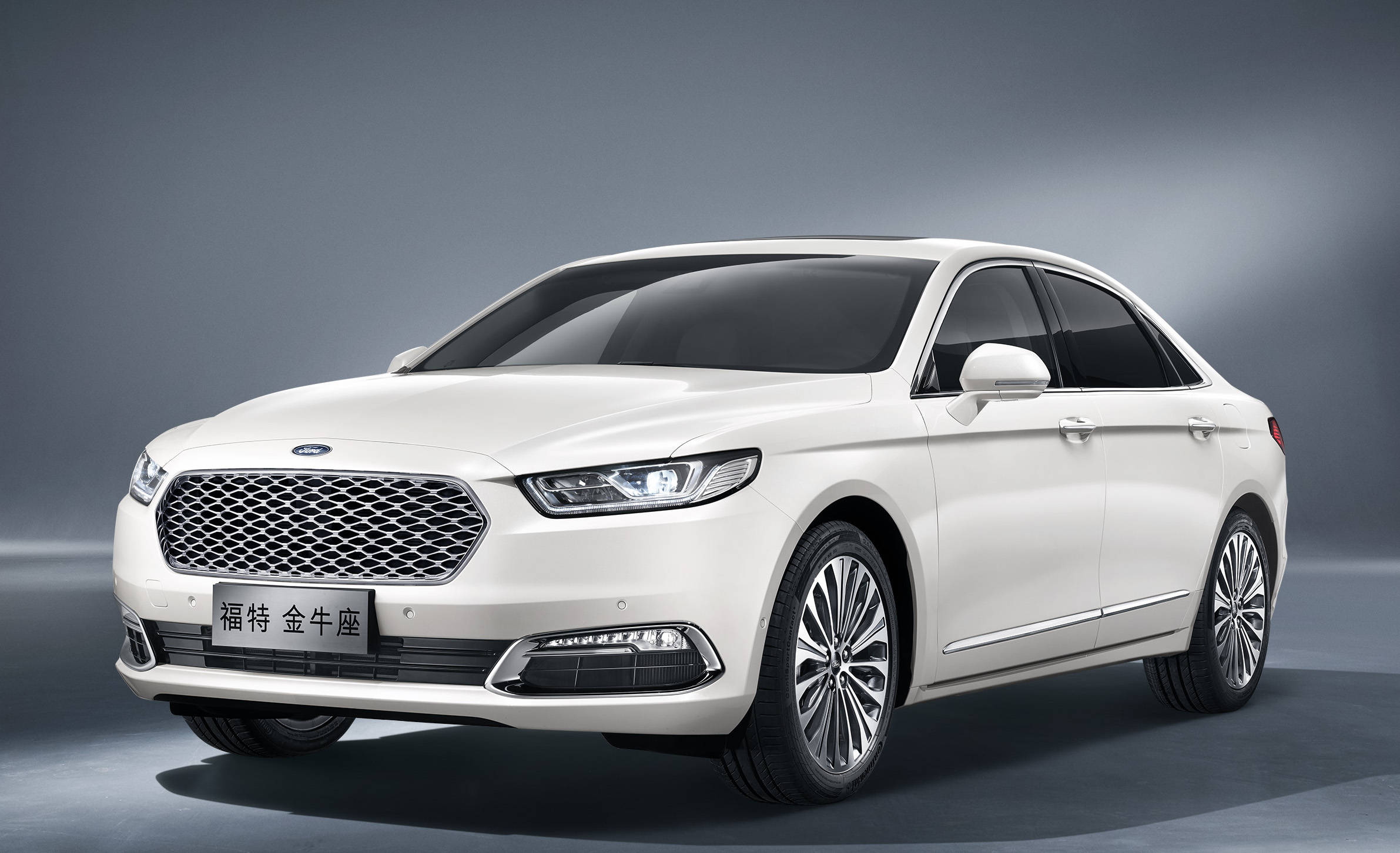 A white 2017 Ford Taurus as sold in China, a large white sedan with Chinese license plates.
