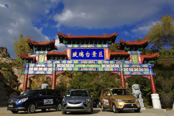 General Motors vehicles in front of Chinese architecture