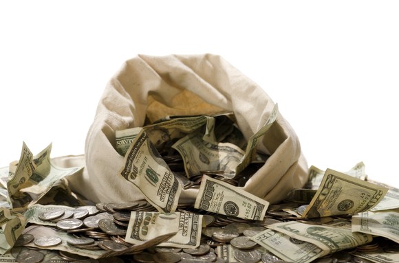 Money spilling out of a burlap sack.