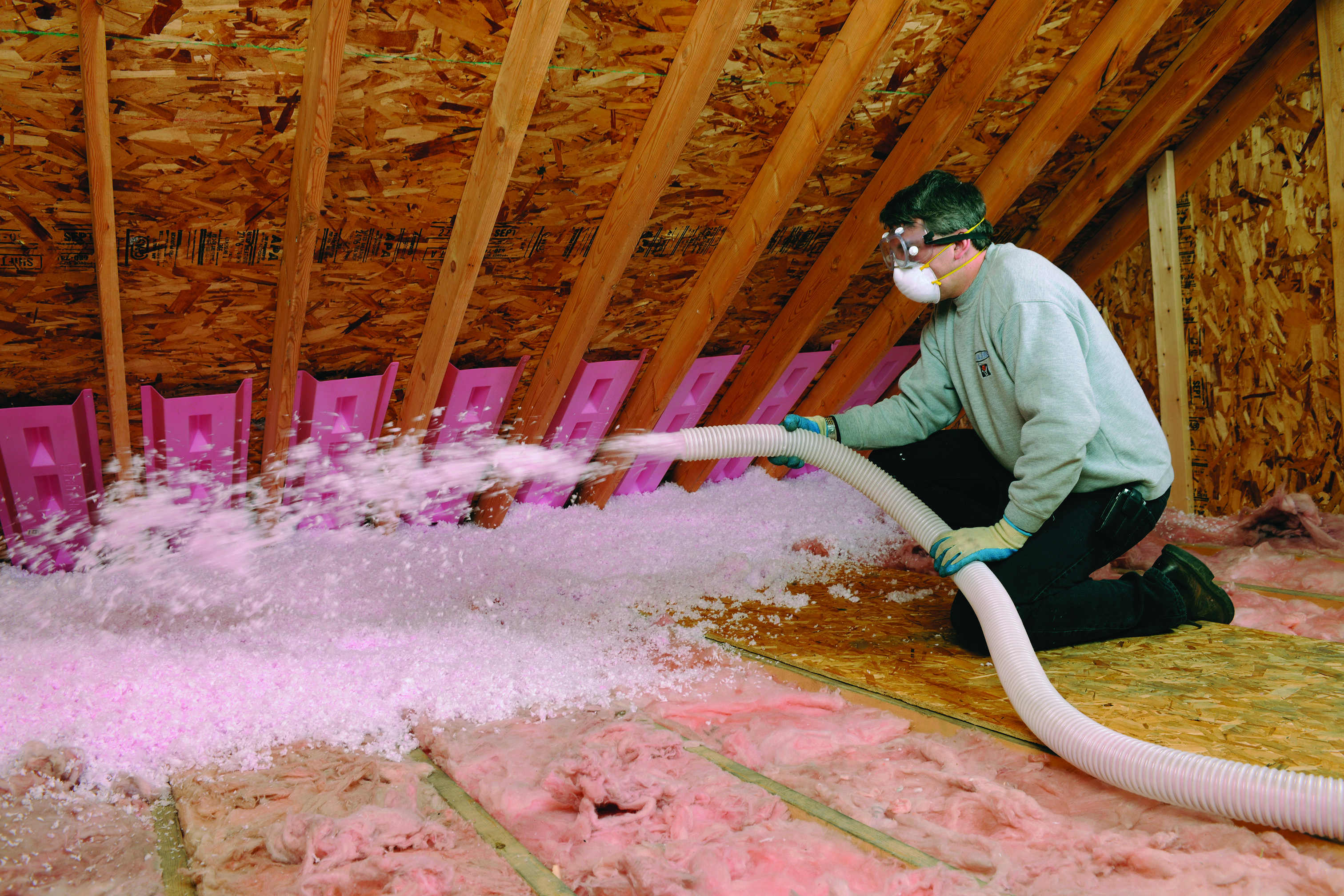 a man applying insulation to an attic
