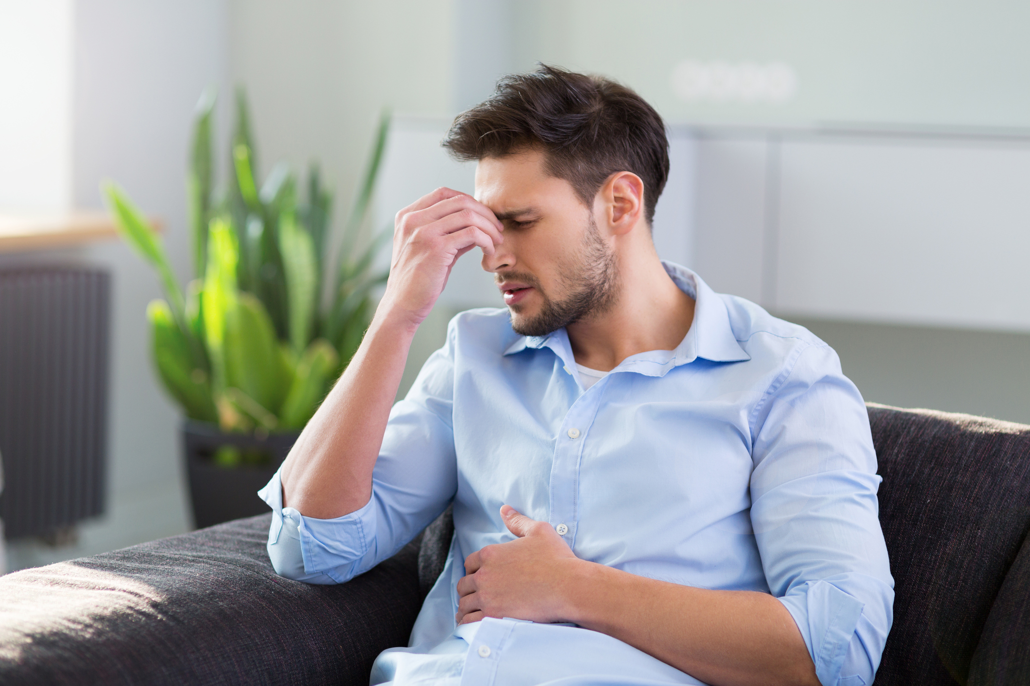 Man pinching his nose to indicate headache