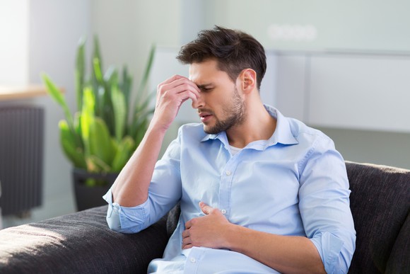 Man pinching his nose to indicate headache