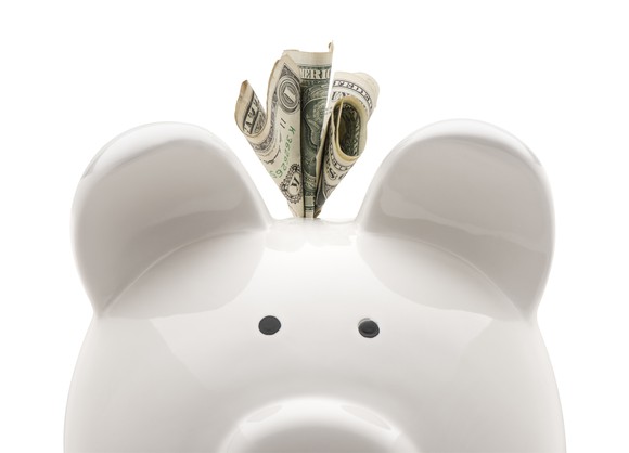 Dollar bill sticking out of piggy bank