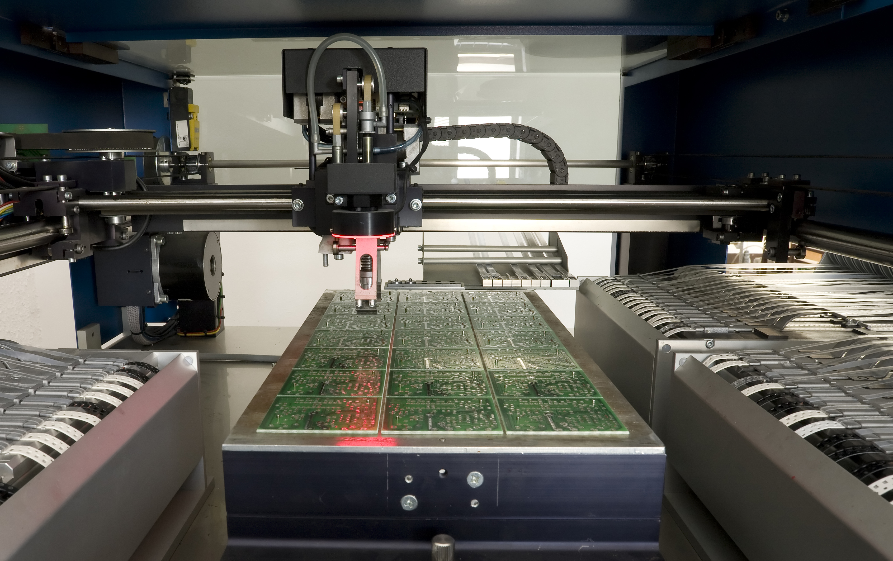 Machines are producing a batch of printed circuit boards.