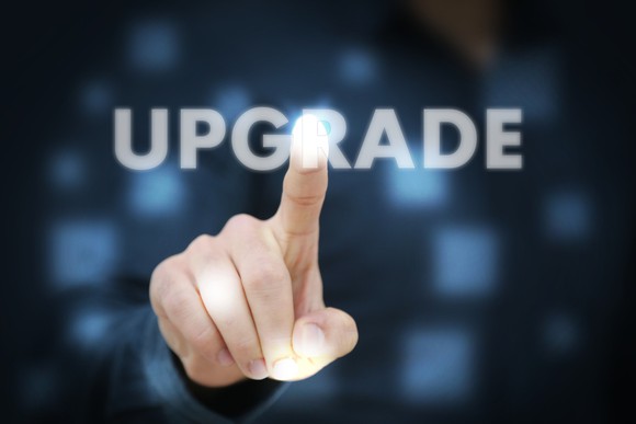 A person pointing to the word "upgrade" on a screen.