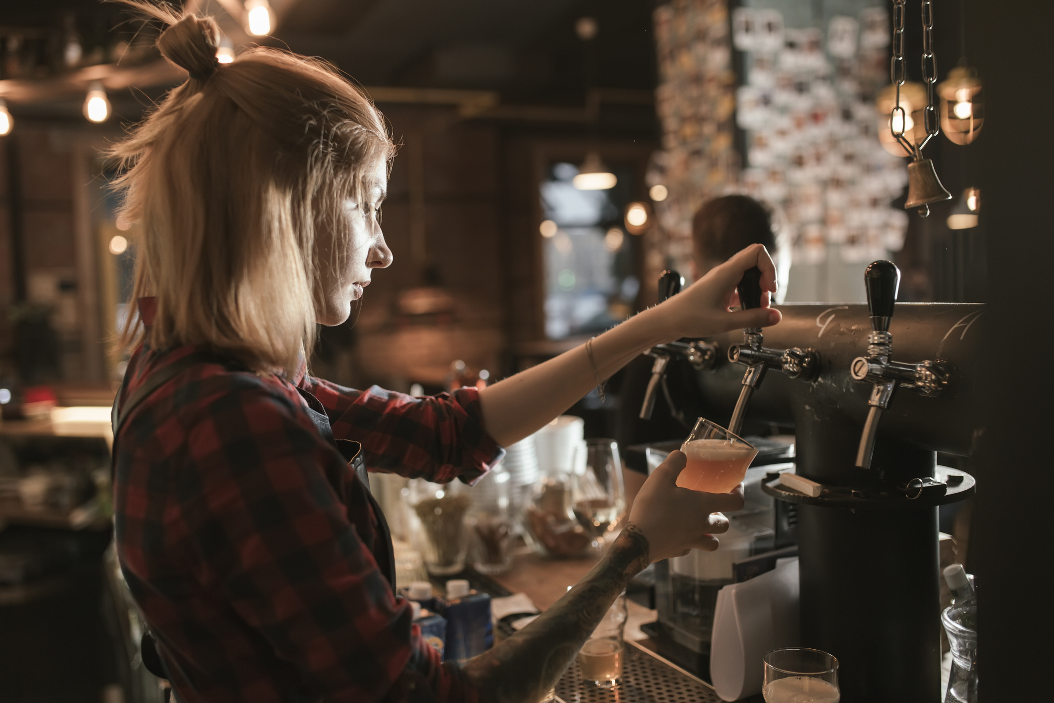 Female bartender pouring beer
