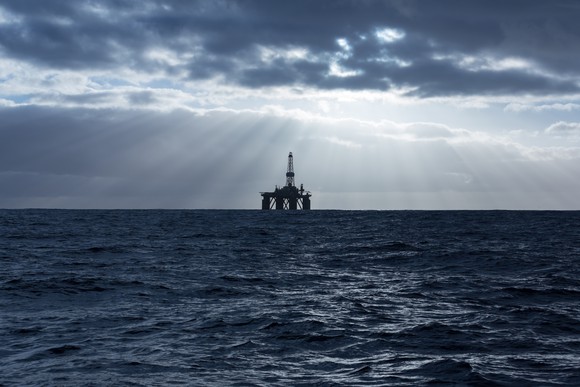 Offshore drilling rig with sun rays coming through the clouds.