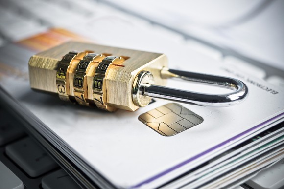 Combination lock on top of a stack of credit cards.