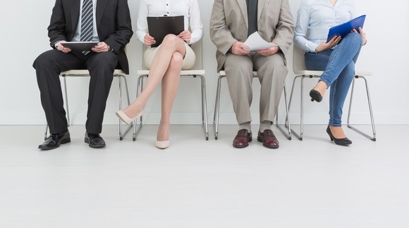 Two women and two men sitting in chairs in a line