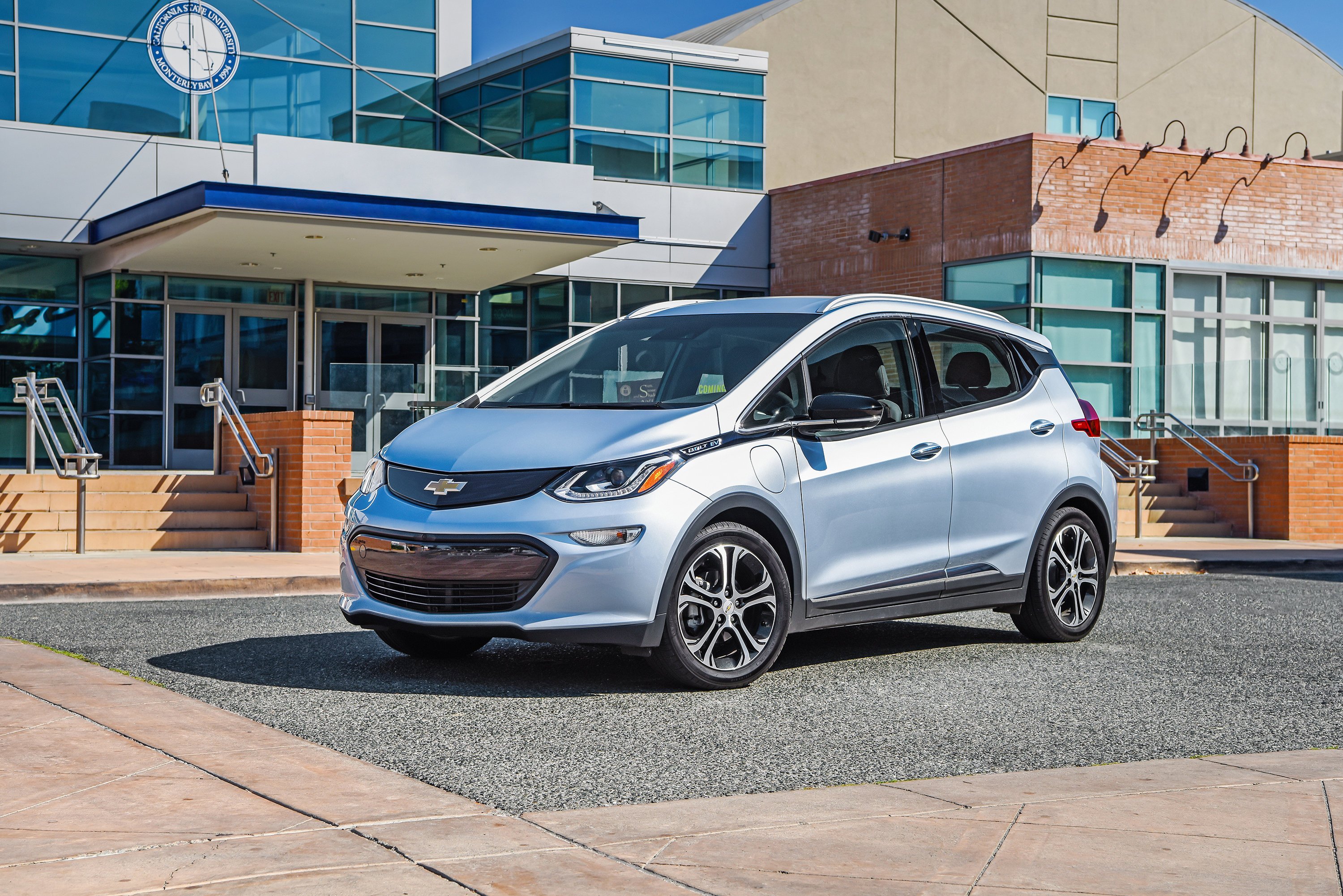 A Chevrolet Bolt EV parked in front of a public building.