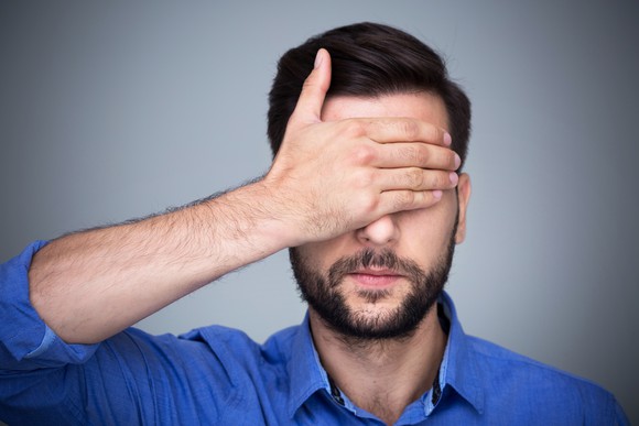 young man covering his eyes