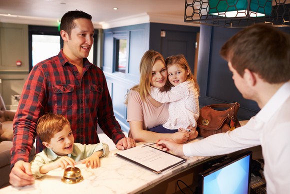 A family at the front desk of a hotel