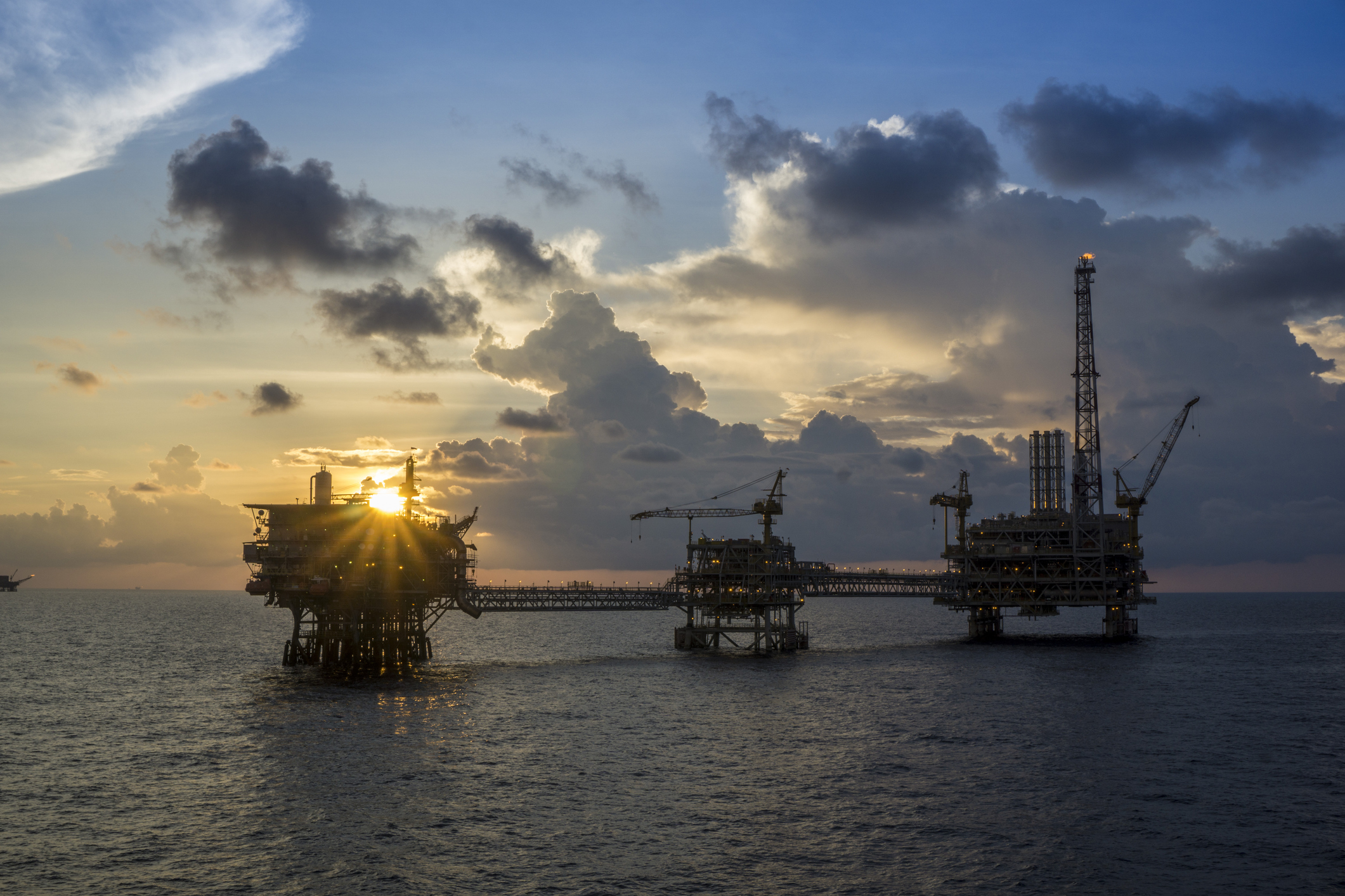An offshore oil and gas platform at sunset.