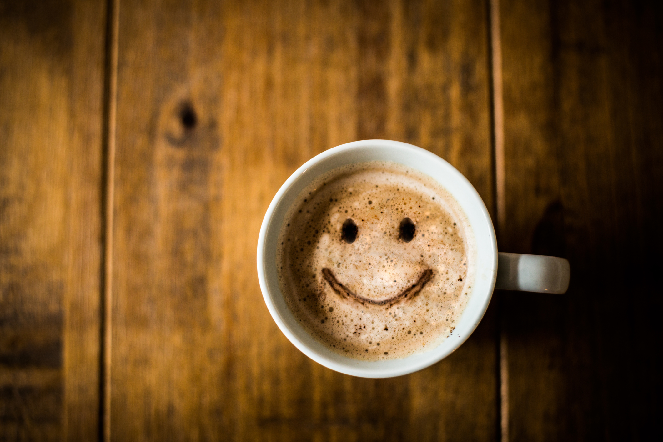 Coffee in a mug with a happy face in the froth