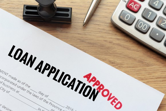 Loan application with "approved" stamp on top.