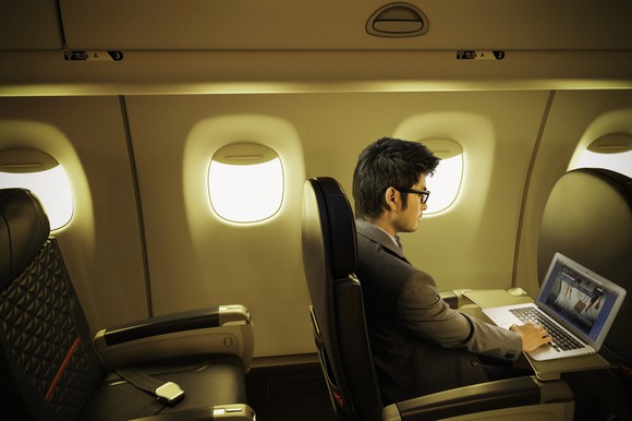A man using his laptop on a Delta flight.
