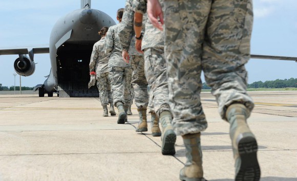 Soldiers walking onto a troop transport plane