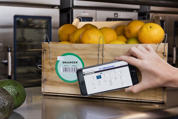 An IBM blockchain solution on a mobile phone being used to track a crate of oranges.