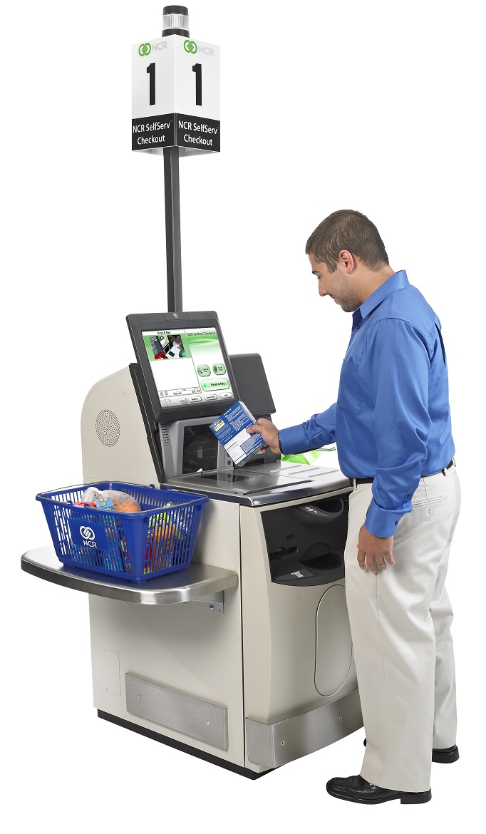 Person scanning groceries at a self-checkout kiosk.