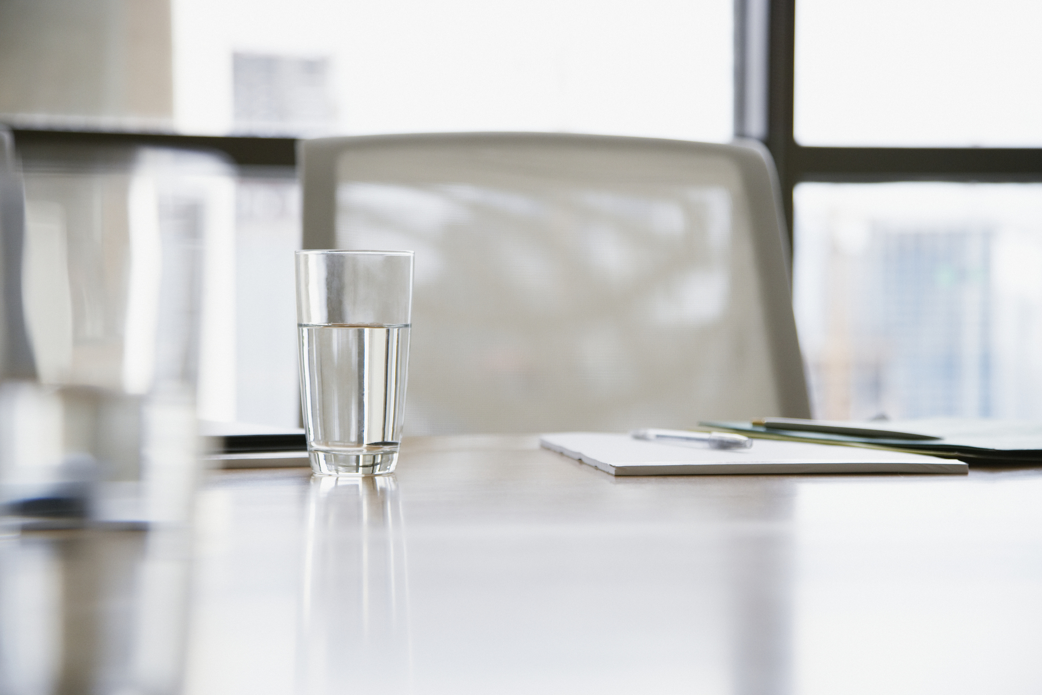 A glass of water sits in front of an empty chair