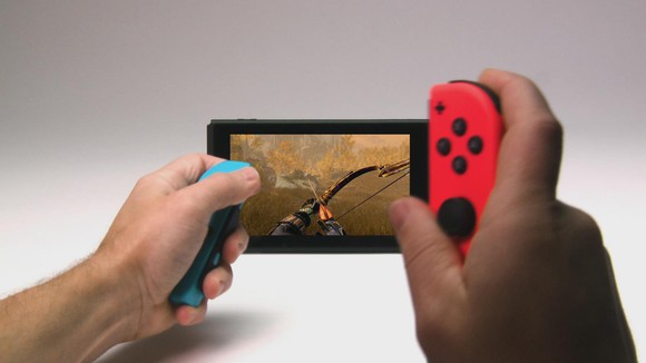 A person holding Switch controllers and looking at the console's screen.