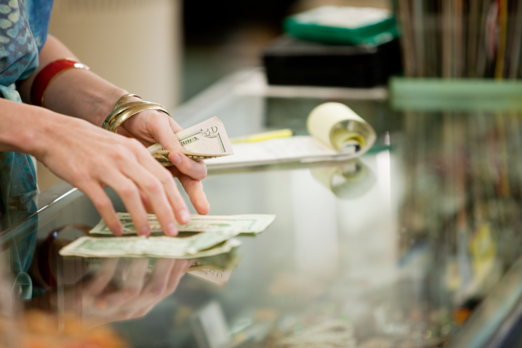 Woman counting money on table.