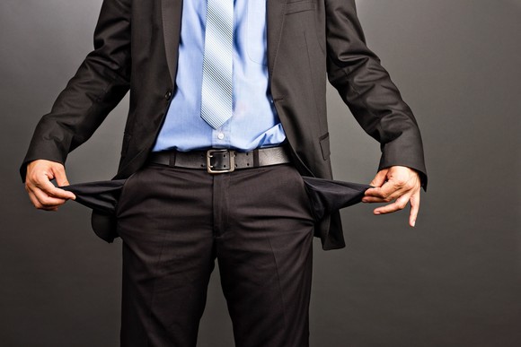 Man in a business suit turning the empty pockets inside out