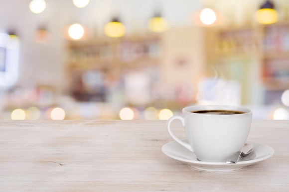A cup of coffee sits on a table.