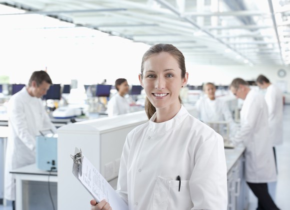 Smiling scientist with a clipboard.