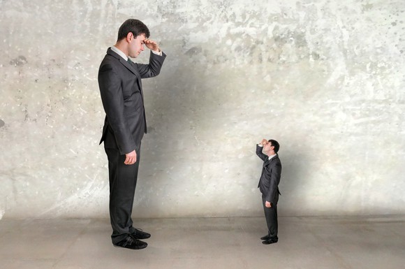 Big and small businessmen looking at each other