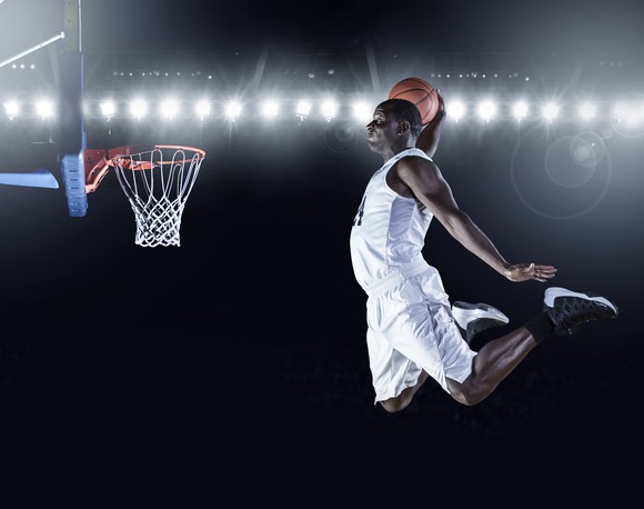 Basketball player dunking basketball