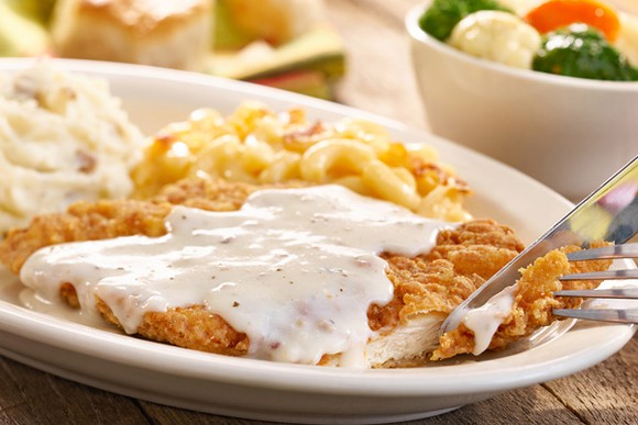 A plate of chicken fried steak and gravy with mashed potatoes from Cracker Barrel.