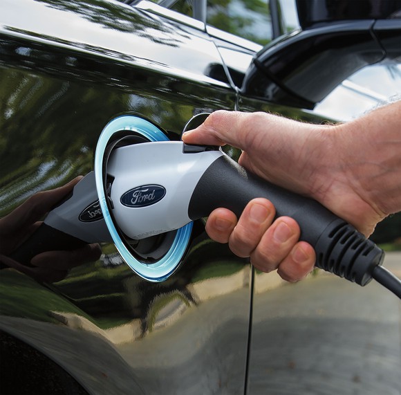 A close-up of a Ford-branded recharging plug plugged into a Fusion Energi hybrid sedan. Image source: Ford Motor Company.