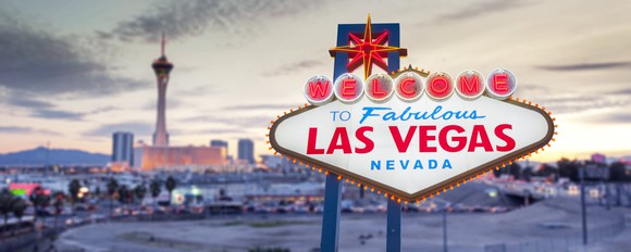 Las Vegas sign with the skyline in the background.