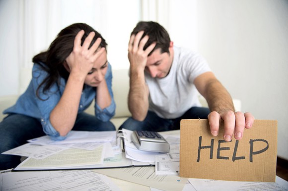 Couple stressed while holding "help" sign