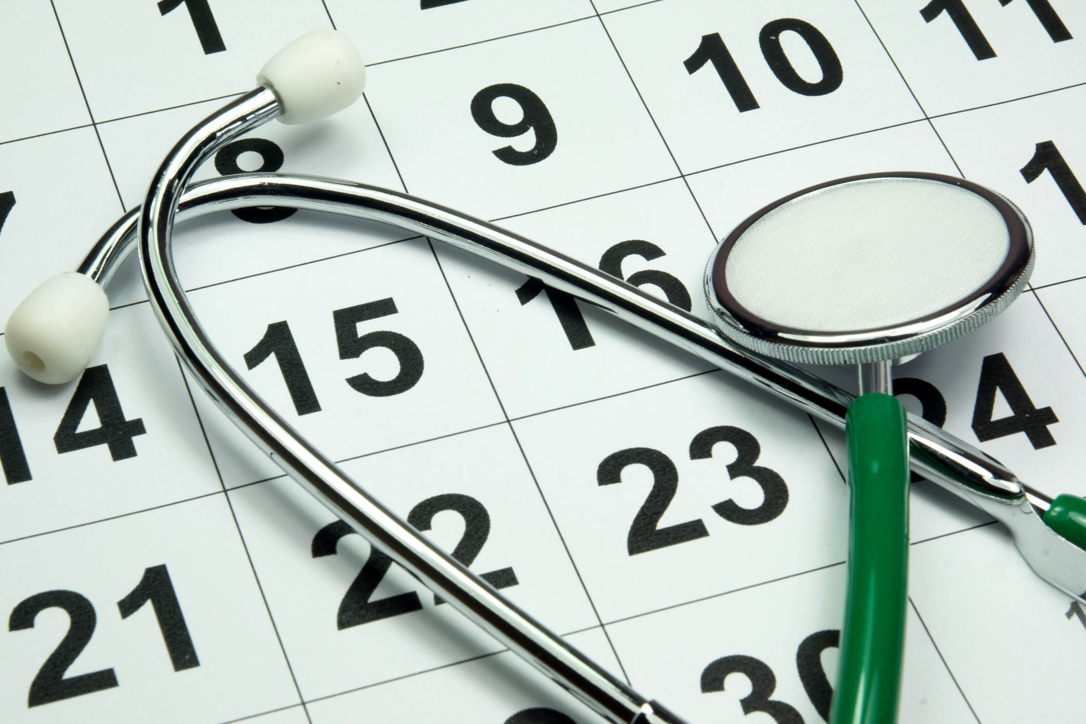 A stethoscope lying atop a calendar. 
