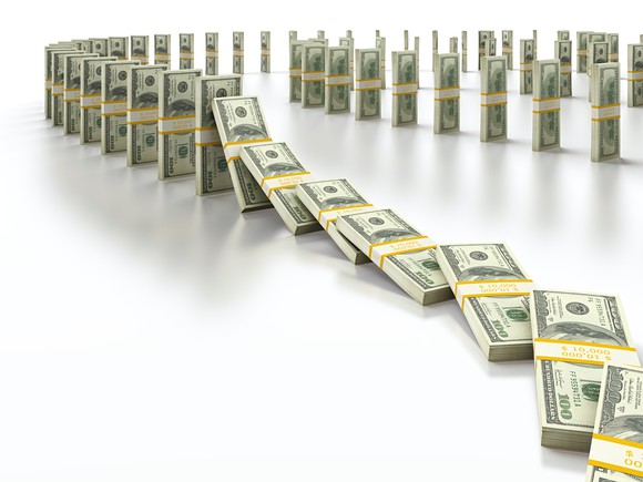 Stacks of money falling like dominoes