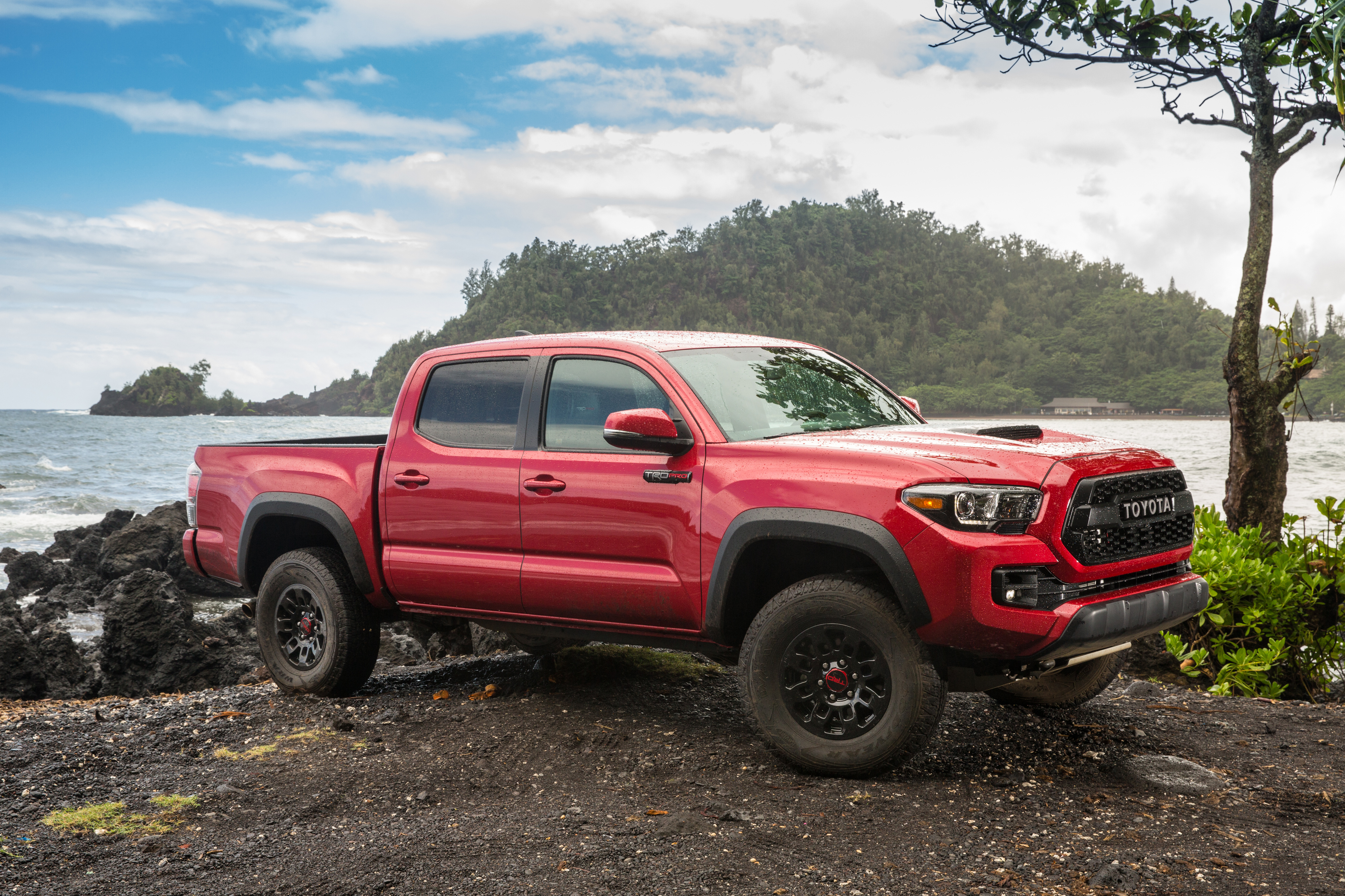 A red 2017 Toyota Tacoma parked by a lake.