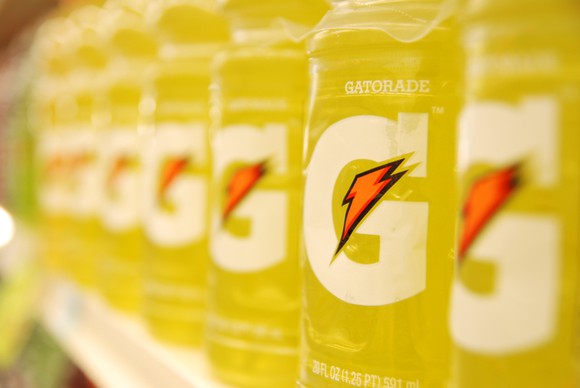 Close up of a row of yellow Gatorade bottles on a store shelf.