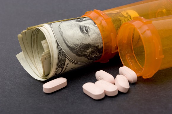 Pills and pill bottles with money in one of the bottles