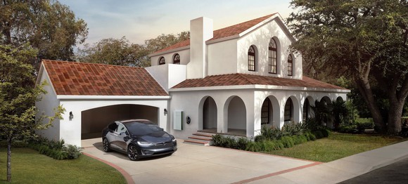 Photo of a white two-story home with tuscan-style clay roof tiles.