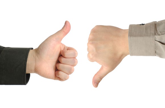 One hand showing a thumbs-up and another showing a thumbs-down sign.